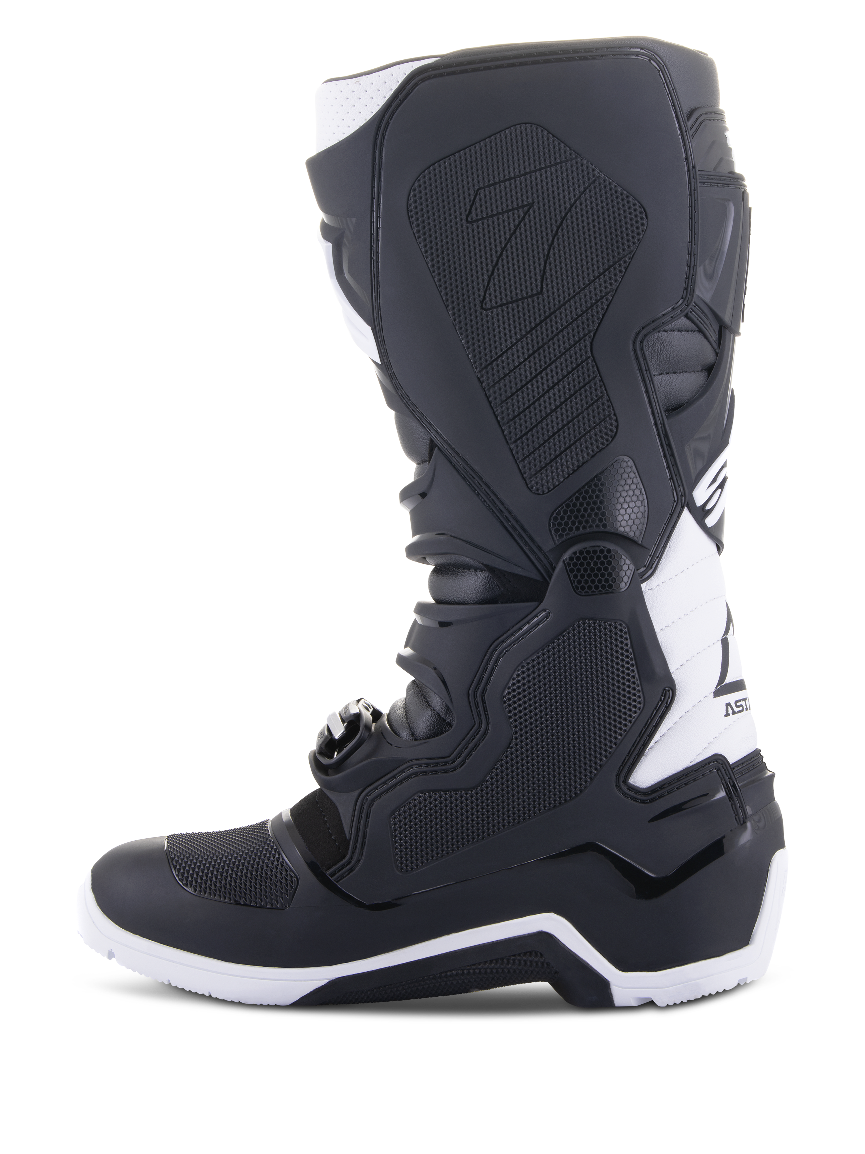 Alpinestars Tech 7 Enduro Drystar® Stiefel, Enduro-Motorradstiefel, Schwarz und Weiß, mediale Seitenansicht mit wabenförmig strukturierten Grip-Panels, TPU-Konstruktion und weißen Akzenten an Ferse und oberem Wadenbereich, professionelles Offroad-Schuhwerk