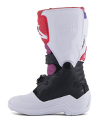 Alpinestars Youth Tech 7S Stiefel, Motocross-Stiefel, White Black Rainbow, mediale Seitenansicht mit weißer Schienbeinplatte und geprägtem Tech Series-Logo, schwarzem unteren Bereich und leuchtend pinken und roten Akzenten, strapazierfähige Schutzausrüstung für jugendliche Offroad-Fahrer