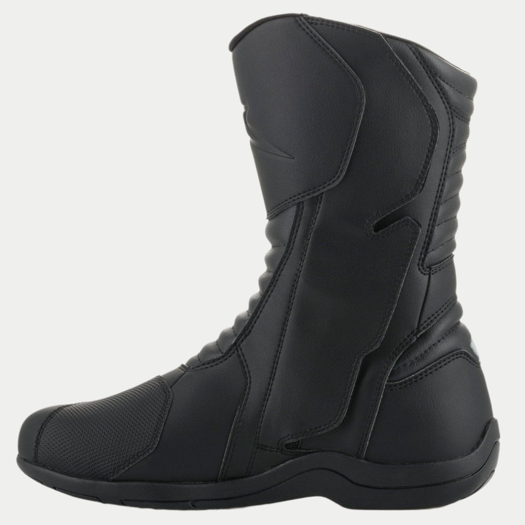 Alpinestars Origin Drystar® Stiefel, schwarze Motorrad-Tourenstiefel, Seitenansicht der medialen Seite mit Einstiegslasche, Mikrofaser-Obermaterial mit vorderen und hinteren Akkordeon-Flexzonen, strapazierfähiges wasserdichtes Design für Straßen- und Adventure-Fahrten