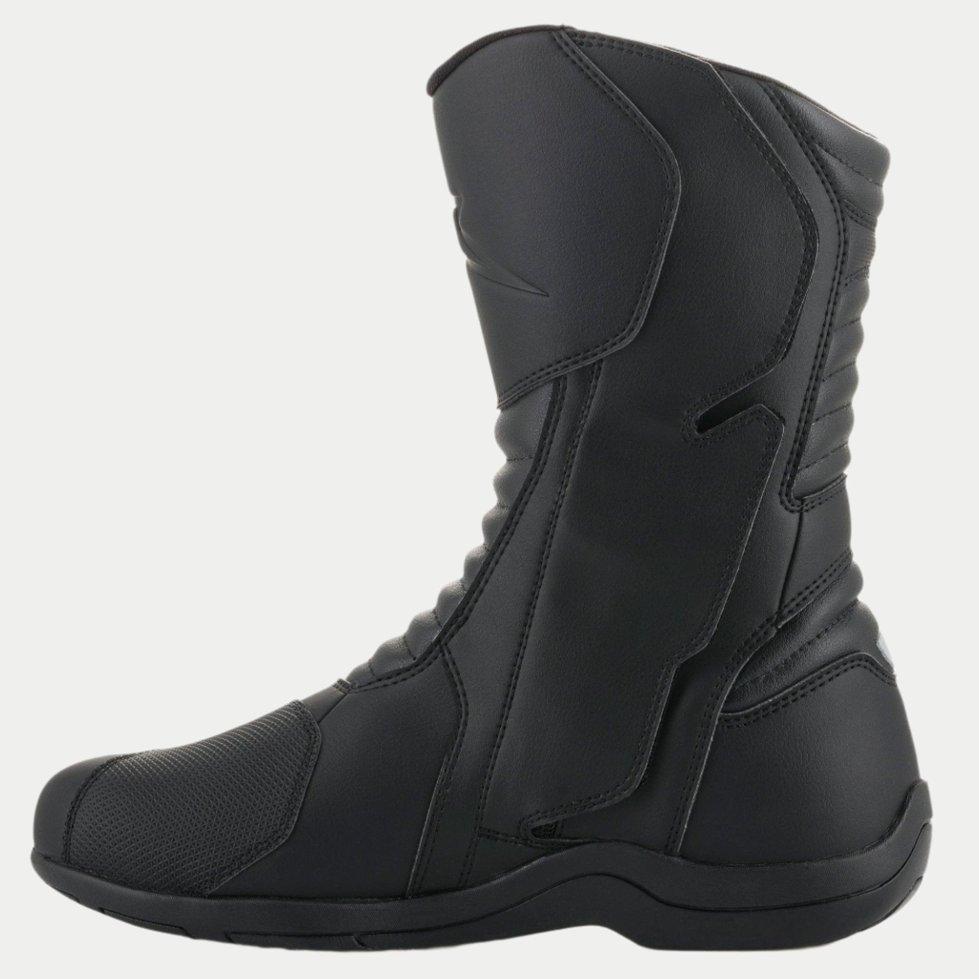 Alpinestars Origin Drystar® Stiefel, schwarze Motorrad-Tourenstiefel, Seitenansicht der medialen Seite mit Einstiegslasche, Mikrofaser-Obermaterial mit vorderen und hinteren Akkordeon-Flexzonen, strapazierfähiges wasserdichtes Design für Straßen- und Adventure-Fahrten
