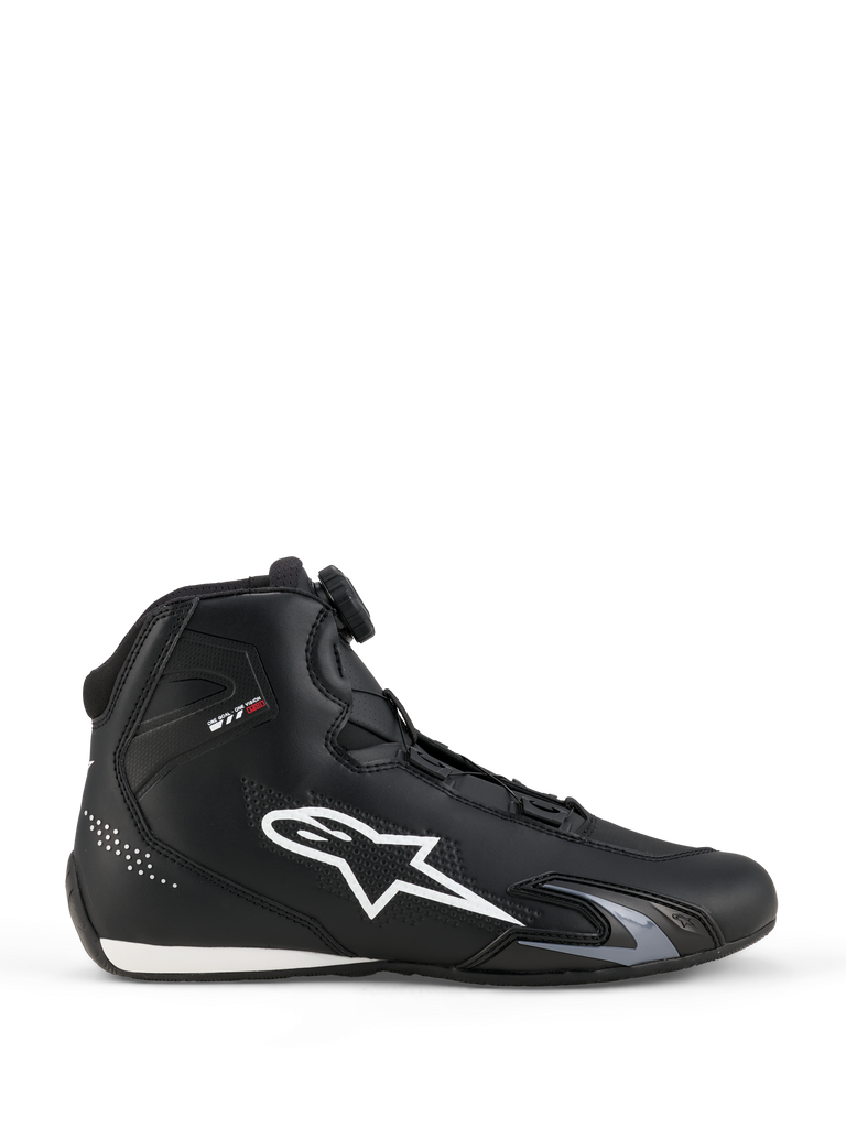 Alpinestars Celer Schuhe, Hohe Sneaker, Schwarz mit weißem Stern-Logo, Sportliches Design mit glänzender Zehenkappe, Gepunktetes Muster an der Ferse, Schwarze Schnürung, Weiß-schwarze Sohle
