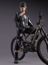 Alpinestars A-Dura Ride Long Sleeve Jersey in Black Camo with orange logo, worn by a rider on a mountain bike in studio.