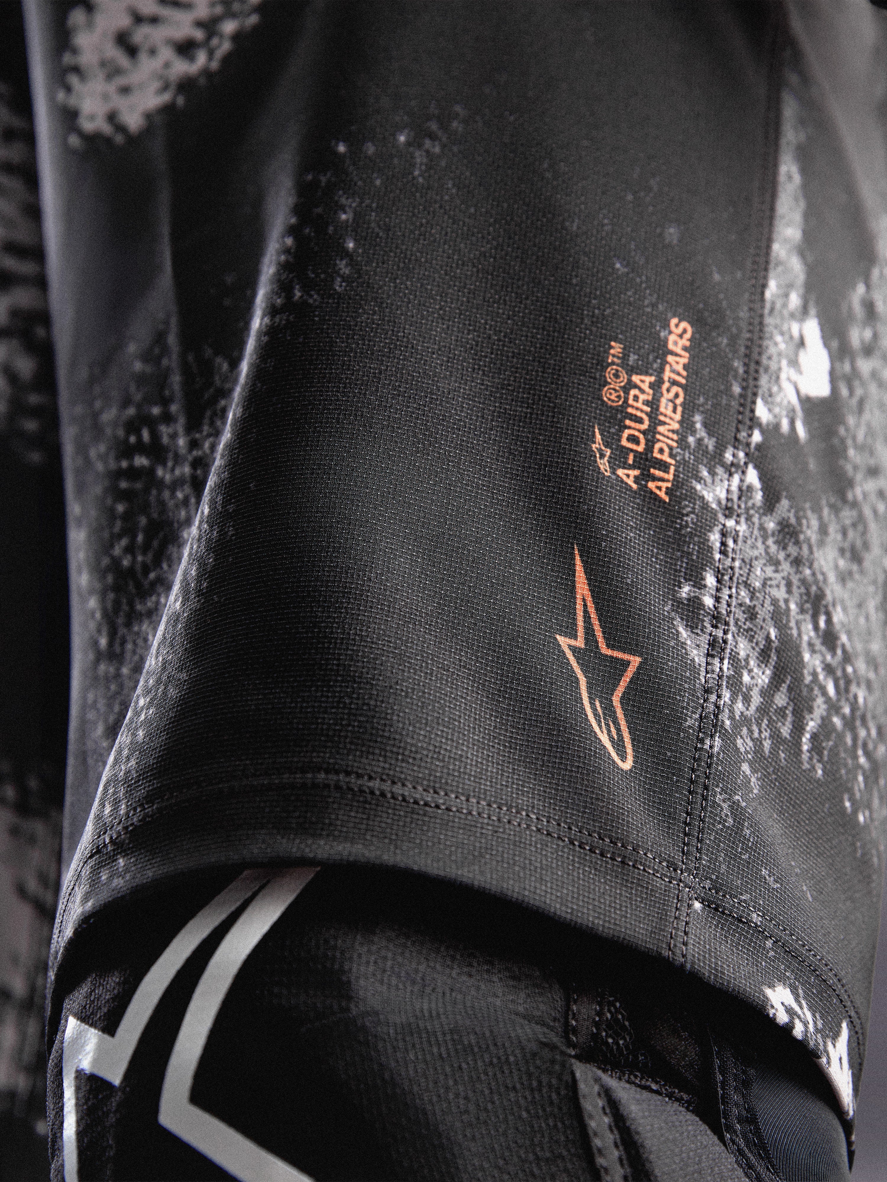 A-Dura Ride Shorts in Black Camo mit orangefarbenem Alpinestars-Logo auf strapazierfähigem 4-Wege-Stretch-Gewebe für MTB.