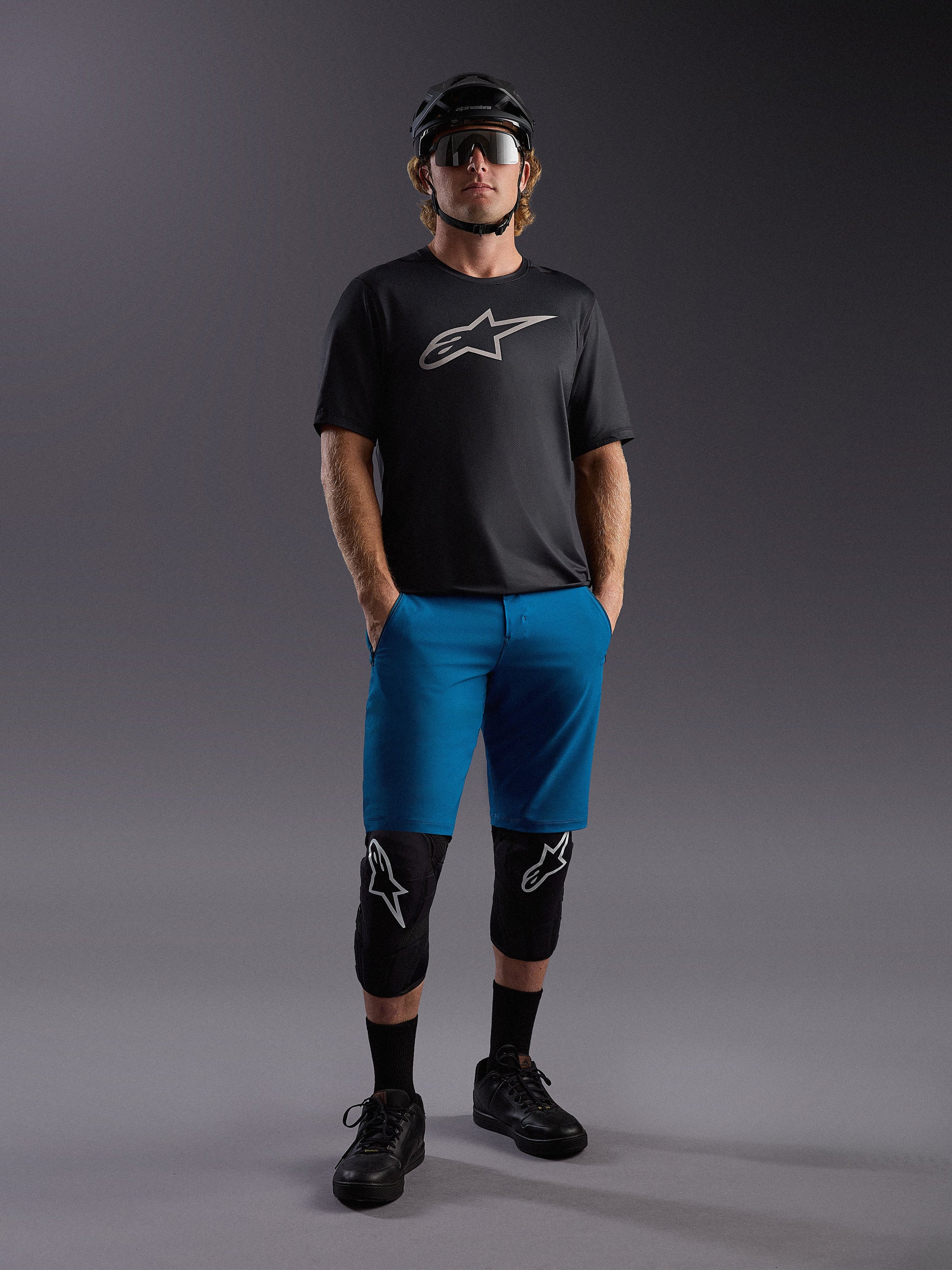 Alpinestars A-Dura Ride SS Jersey und blaue Shorts, komplettes Mountainbike-Outfit mit Protektoren und Helm.