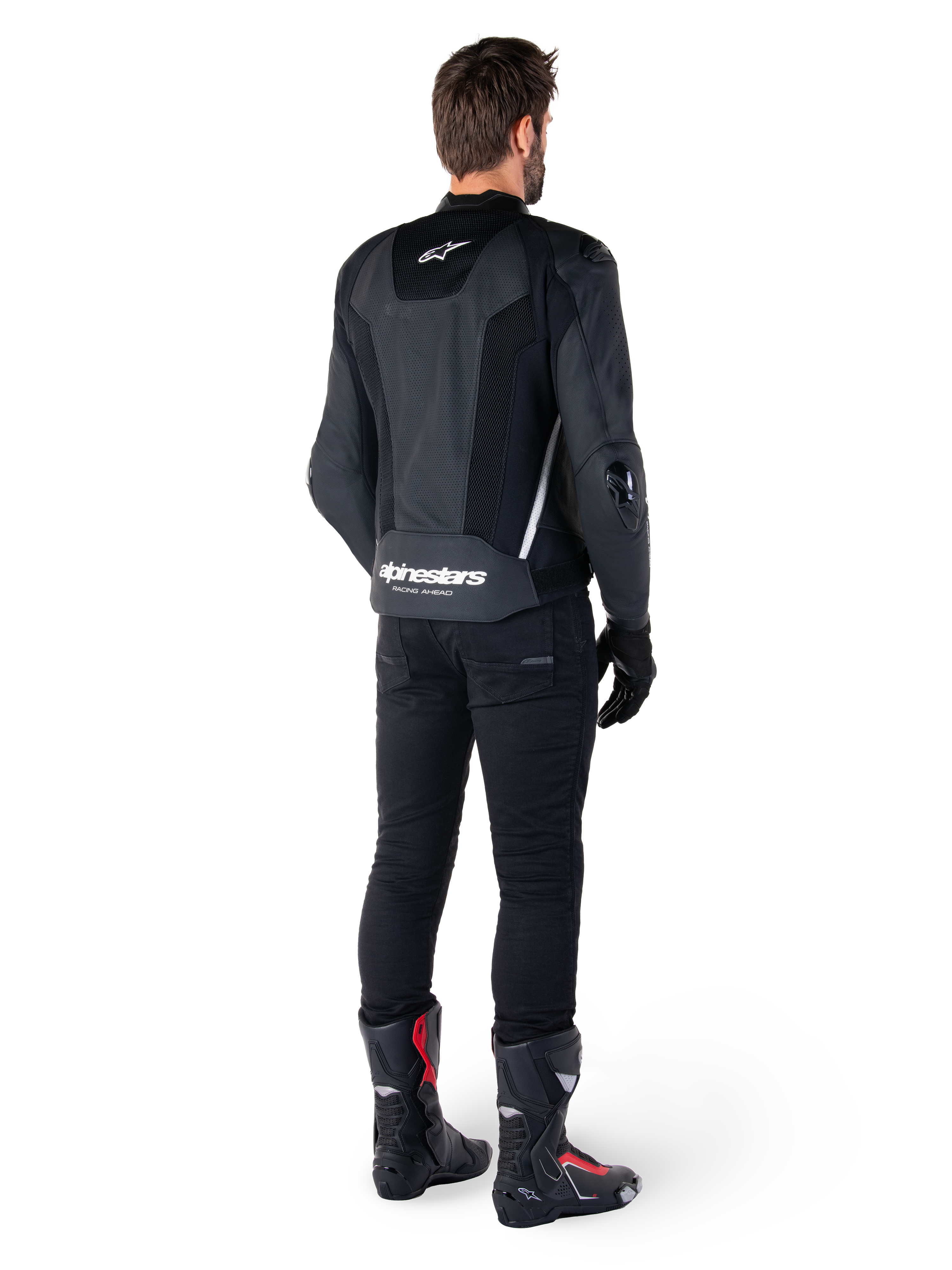 Alpinestars Missile V3 Airflow Leather Jacket, Black and White, rear view worn with black technical pants and racing boots, featuring perforated leather back panels and bold Alpinestars branding on the lower back.