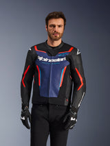 Alpinestars GP Force V2 Lederjacke, Schwarz, Blau und Fluo-Rot, getragen von einem männlichen Model mit schwarzen Handschuhen und Hose, mit einem blauen Brustpanel mit 'Alpinestars Racing Ahead'-Schriftzug, roten Akzenten und externen Schulterschilden, Sport-Motorradschutzausrüstung