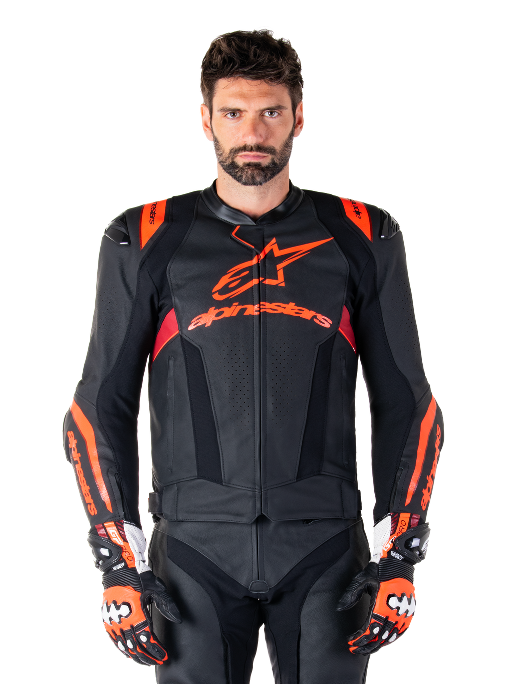 Alpinestars Missile V3 Ignition Lederjacke, Motorrad-Rennjacke, Schwarz und Fluo-Rot, getragen mit passenden Rennhandschuhen und Lederhose, mit perforierter Belüftung und markantem Alpinestars-Branding, professionelle Rennausrüstung