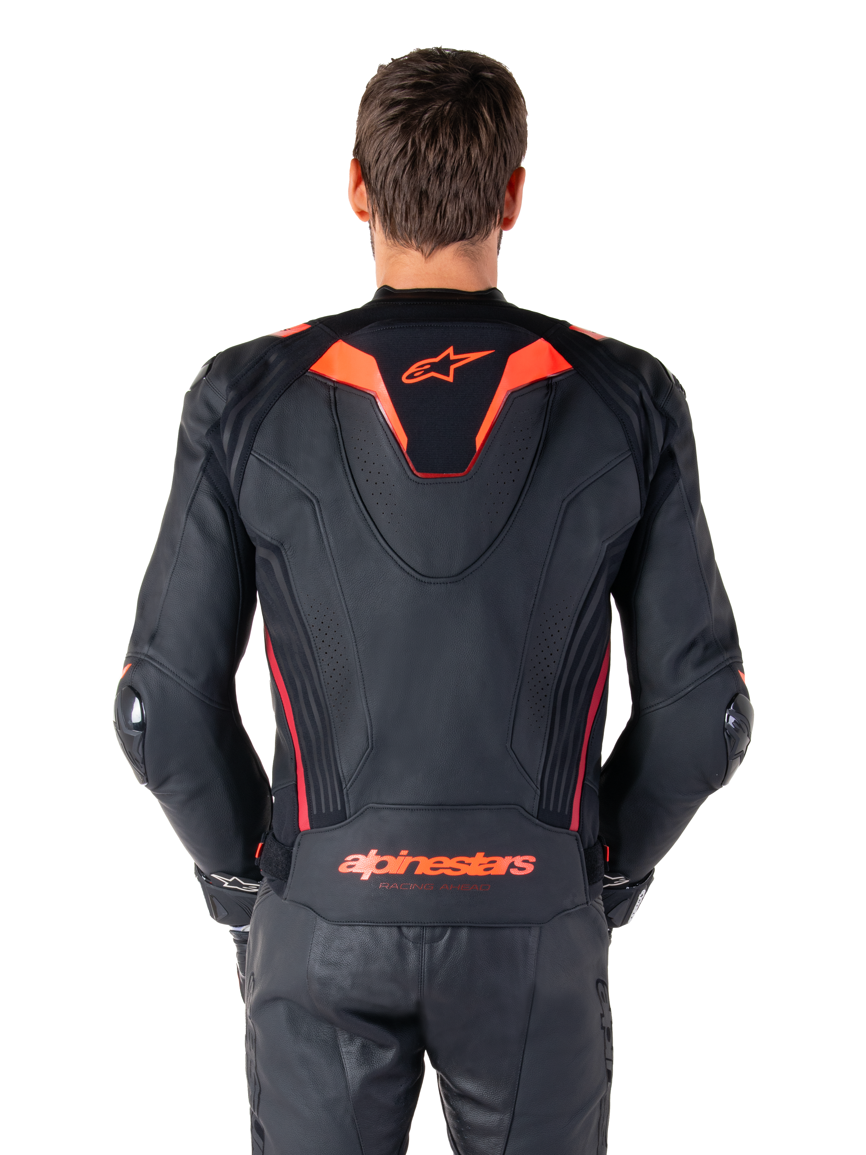 Alpinestars Missile V3 Ignition Lederjacke, Rückansicht, Schwarz mit Akzenten in Red Fluo und Dark Red, mit sportlichem Aero-Höcker, Alpinestars-Branding auf dem Rücken, getragen mit passender schwarzer Leder-Motorradhose, Performance-Motorrad-Rennausrüstung