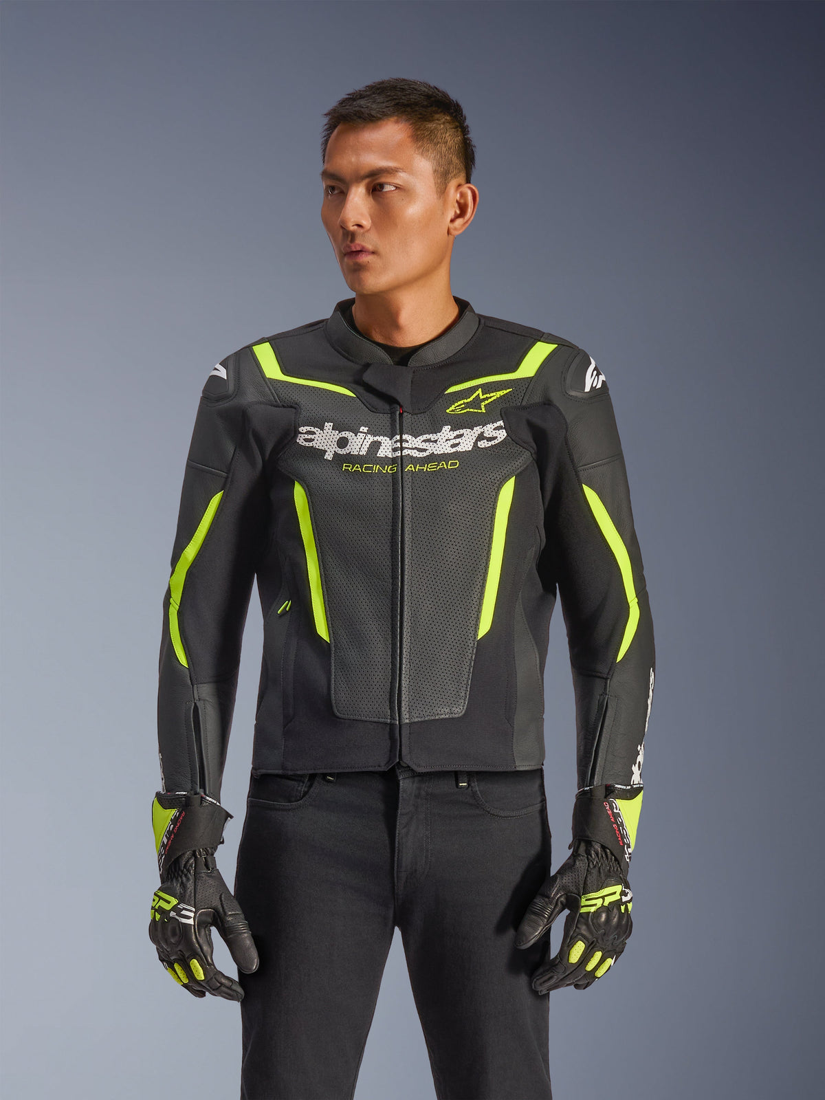 Alpinestars GP Force V2 Air Lederjacke, Schwarz und Neongelb, perforierte Motorrad-Lederjacke mit Schutzpanzerung und Neon-Akzenten, getragen mit passenden Rennhandschuhen und schwarzer Hose, athletische Sport-Passform mit markantem Branding