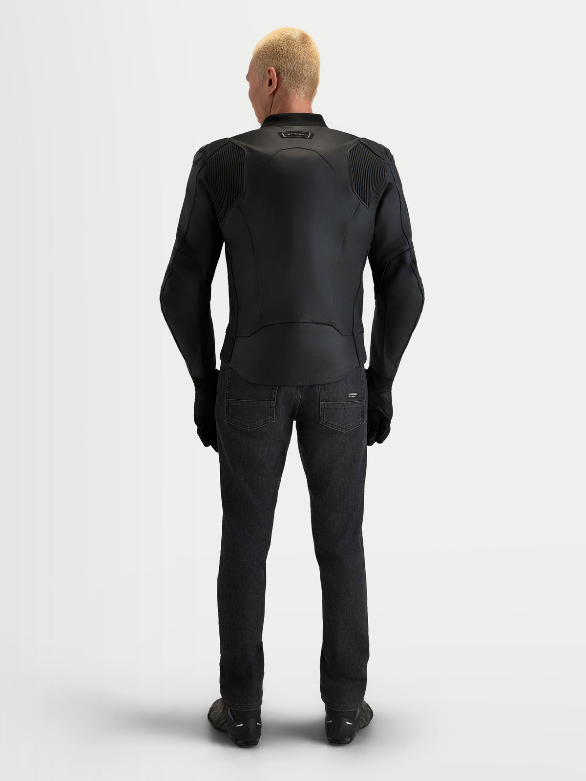 Alpinestars Caliber V2 Leather Jacket, Men's Black Motorcycle Jacket, featuring a full-grain bovine leather construction, accordion mobility panels, and low-profile shoulders, rear view of a model wearing sport road riding gear