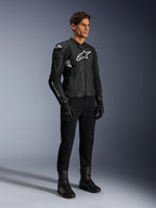 Alpinestars Dusk Airflow Lederjacke, Schwarz und Weiß, präsentiert mit schwarzer Motorradhose, Handschuhen und Stiefeln, mit perforierten Lederbahnen und weißem Logo-Branding, sportlicher Road-Racing-Stil.