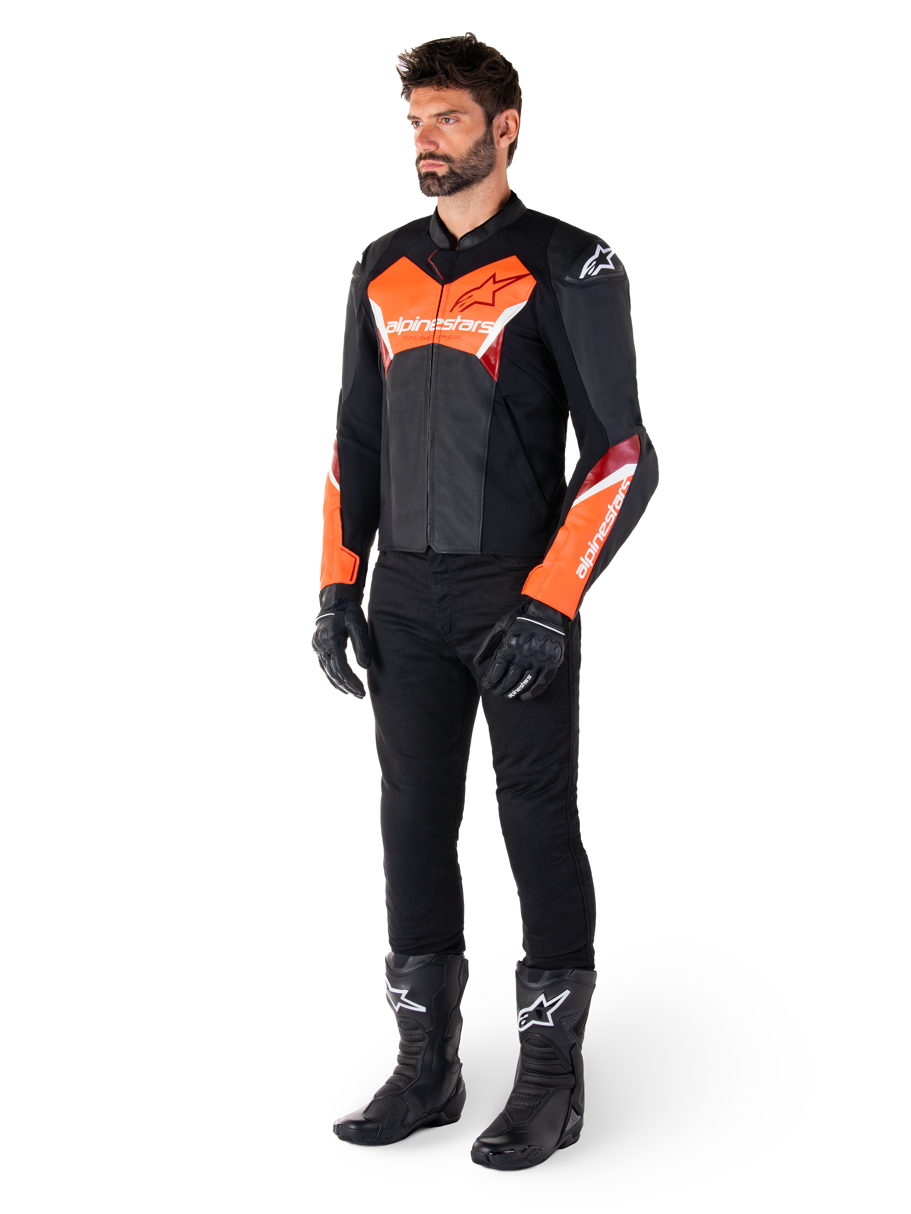 Male rider wearing the Alpinestars Faster V3 Leather Jacket in Black and Red Fluo, paired with black riding pants, gloves, and boots. The jacket features a race-derived silhouette with bold fluorescent red accents on the chest and sleeves, white Alpinestars branding, and a premium leather construction.