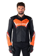 Alpinestars Faster V3 Airflow Lederjacke, Motorradjacke, Schwarz und Rot Fluo, perforierte Lederkonstruktion mit weißen und roten Akzenten, getragen mit schwarzen Handschuhen, Performance-Straßenbekleidung