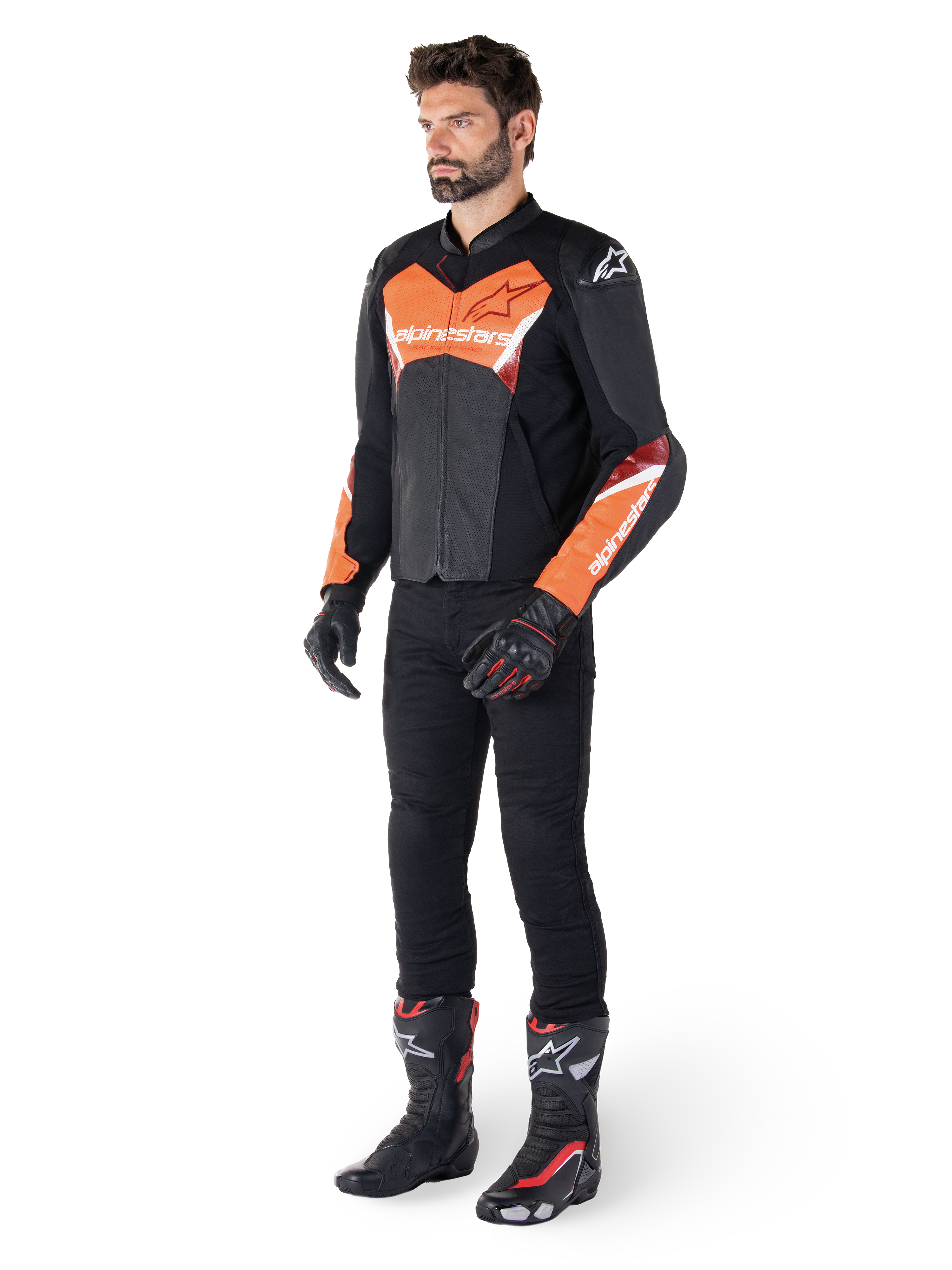 Alpinestars Faster V3 Airflow Lederjacke, Schwarz und Rot Fluo, getragen von einem männlichen Model mit schwarzer Motorradhose, Handschuhen und Rennstiefeln, mit perforiertem Leder und sportlicher Silhouette.