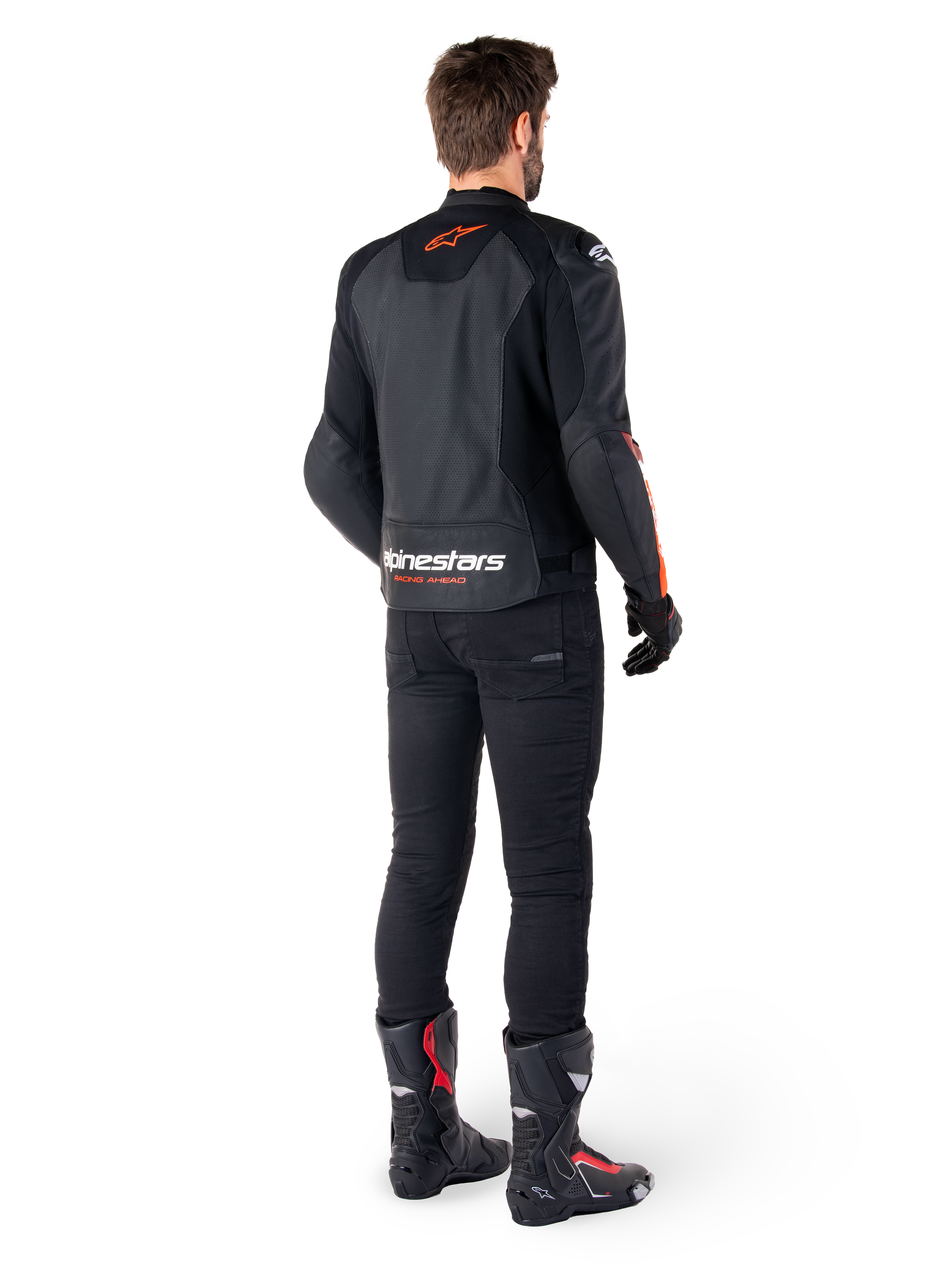 Alpinestars Faster V3 Airflow Lederjacke, Schwarz und Fluo-Rot, Rückansicht an einem Fahrer, mit perforierten Ledereinsätzen und markantem Branding, getragen mit schwarzer Hose und Motorradstiefeln, sportliche Motorradausrüstung.