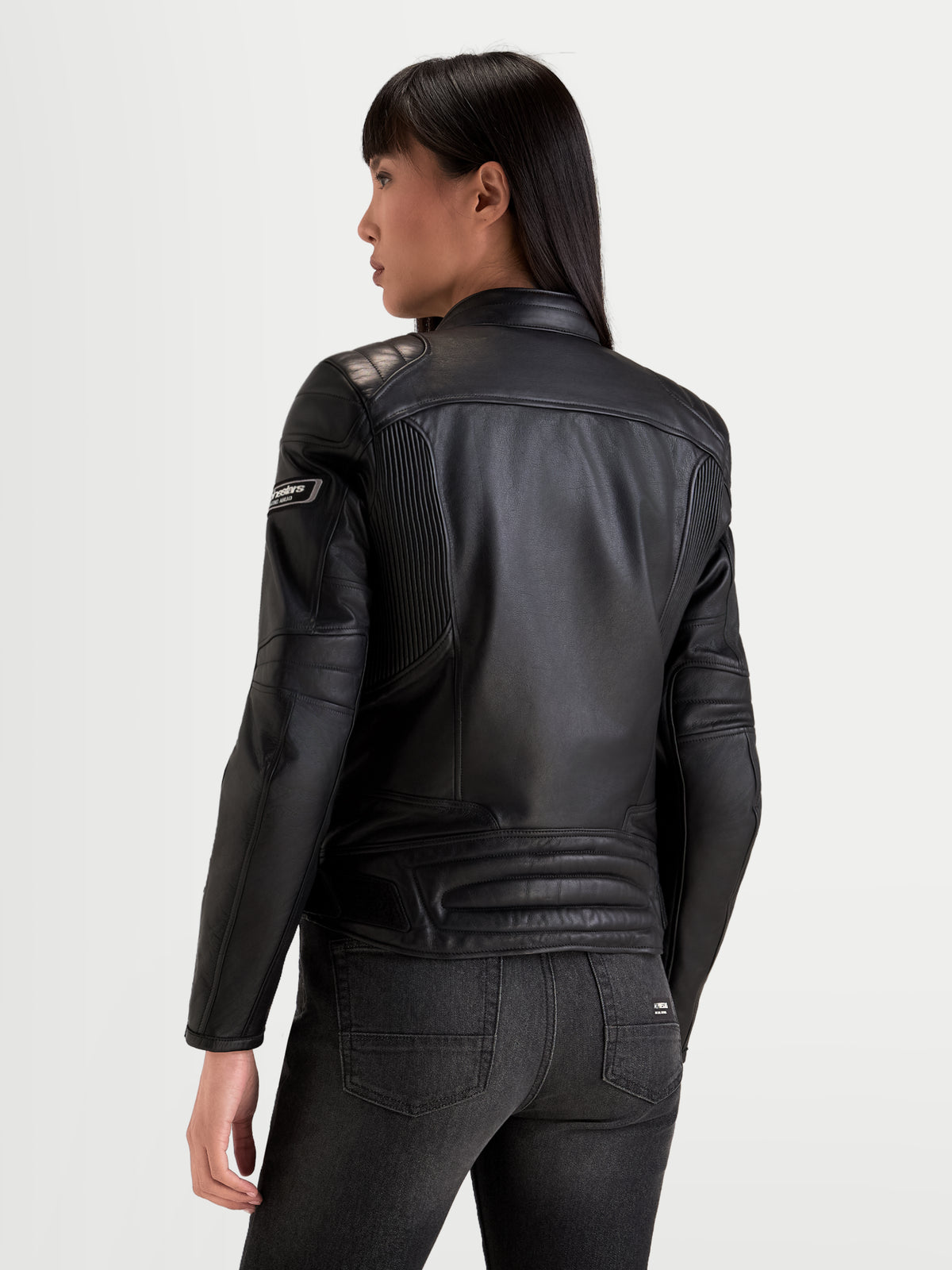 Alpinestars Revea Damen Lederjacke, urbane Motorradjacke aus Leder in Schwarz, Rückansicht mit hochwertiger Vollnarbenleder-Konstruktion und Schulterpolsterung, getragen von einem Model