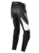 Alpinestars Stella Missile V3 Lederhose, Motorrad-Rennhose für Damen, Schwarz mit weißen Akzenten, Dreiviertel-Rückansicht mit Akkordeon-Stretch-Einsätzen am unteren Rücken, Alpinestars-Logo am Oberschenkel und integrierten Knieschleifern für sportliches Fahren.