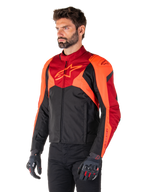 Alpinestars T-Jaws V4 Waterproof Jacket, Black Red Fluo and Dark Red, worn by a male model with black pants and motorcycle gloves, aggressive sport silhouette with Alpinestars logo on the chest, three-quarter view
