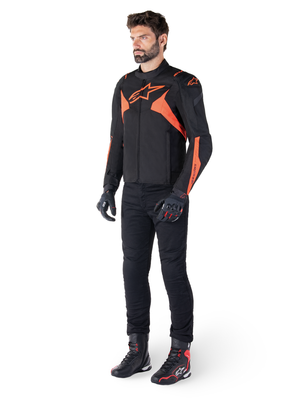 Alpinestars T-Jaws V4 Waterproof Jacket, Black and Red Fluo, worn by a male model with black pants, gloves, and boots, featuring bright orange accents and the Alpinestars logo, sporty design for motorcycle riding