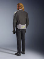 Alpinestars T-Jaws V4 Waterproof Jacket, back view, Black Ice Gray and Dark Gray, featuring a neon yellow Alpinestars logo on the lower back, worn with black pants and motorcycle gloves, sport-styled riding apparel