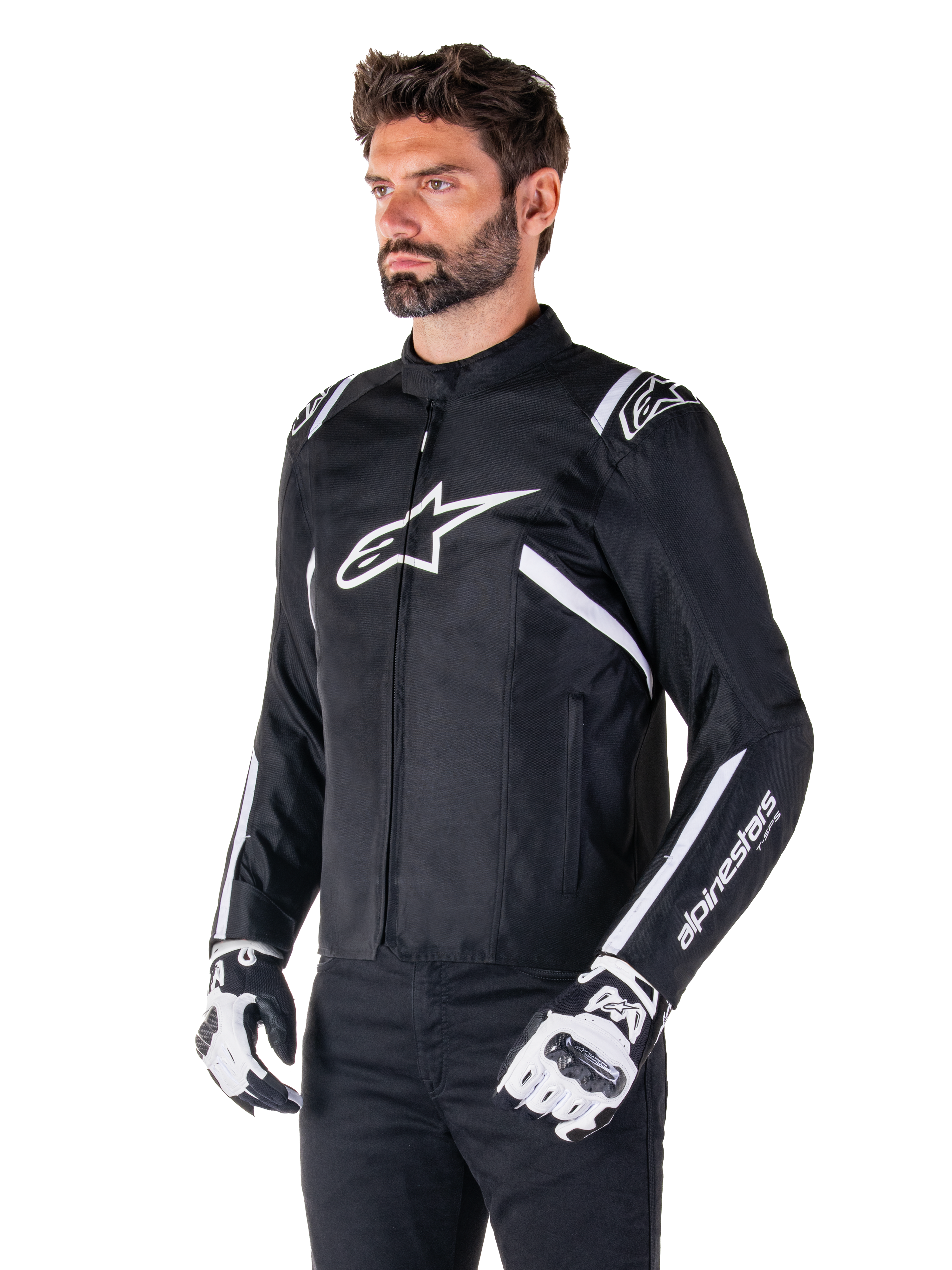 Alpinestars T-SPS V2 Waterproof Jacke, Schwarz und Weiß, getragen von einem männlichen Model mit passenden Motorradhandschuhen, Textiljacke im Sportschnitt mit weißen Alpinestars-Logos auf Brust und Schultern, „alpinestars T-SPS“-Branding am Ärmel, elegante vom Rennsport inspirierte Motorradausrüstung