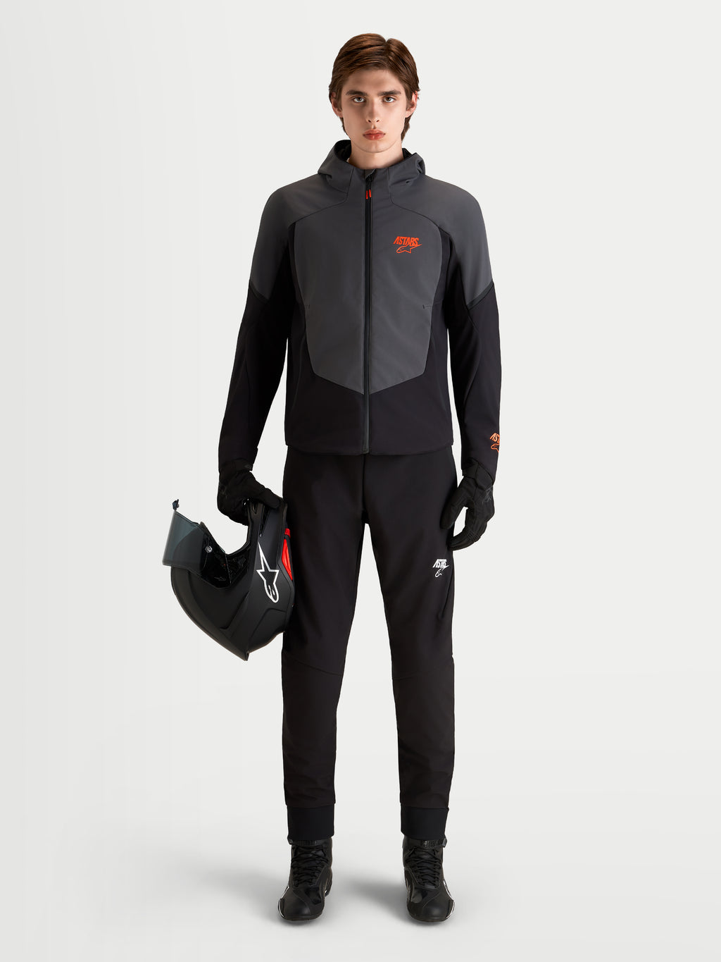 Alpinestars Aeroshell WP Jacke, Herren-Motorradjacke mit Kapuze in Schwarz und Dunkelgrau, CE-zertifiziert, getragen von einem Model mit Motorradhelm
