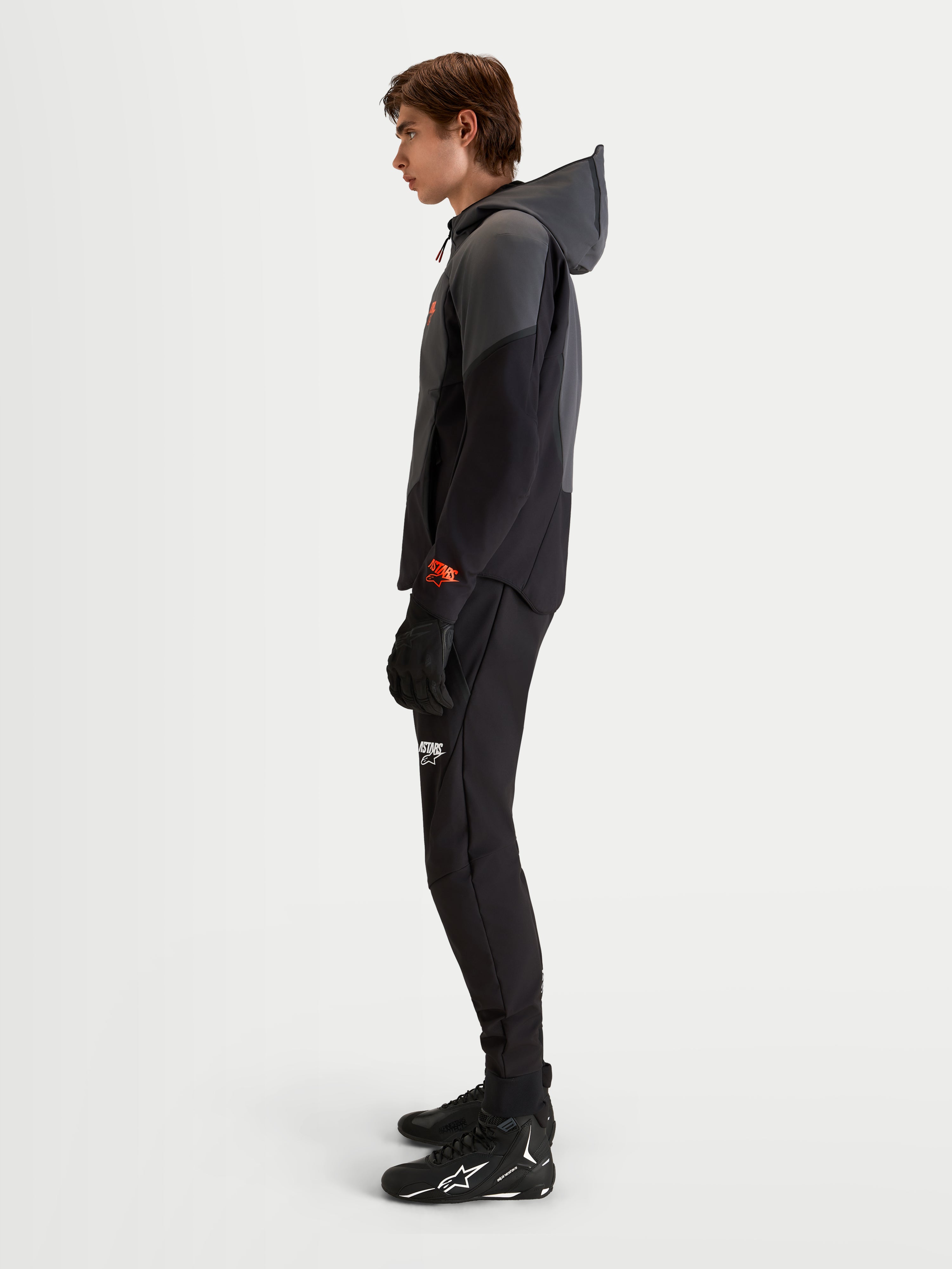 Alpinestars Aeroshell Waterproof Jacke, Herren-Motorradjacke in Schwarz und Dunkelgrau mit Kapuze, Modell in Seitenansicht, CE-zertifiziert