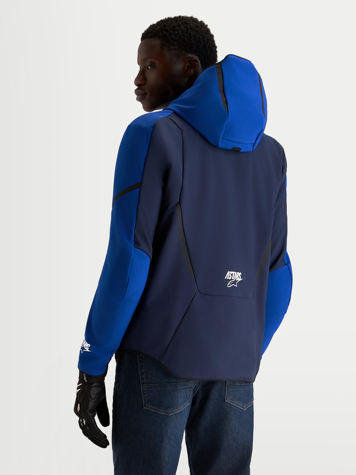 Alpinestars Aeroshell Wp Jacke, Herren-Motorradsport-Softshelljacke, Nachtblau und Blau, Kapuze und CE-zertifizierter Schutz, Rückansicht des Models mit Fahrhandschuhen