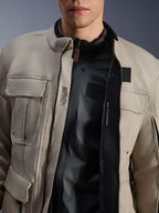 Alpinestars Borrego Drystar® Jacket in Warm Gray, close-up view showing the unzipped front, black internal liner, and interior technical text including 'ALPINESTARS PROTECTS' and chest protector compatibility, rugged adventure motorcycle style.