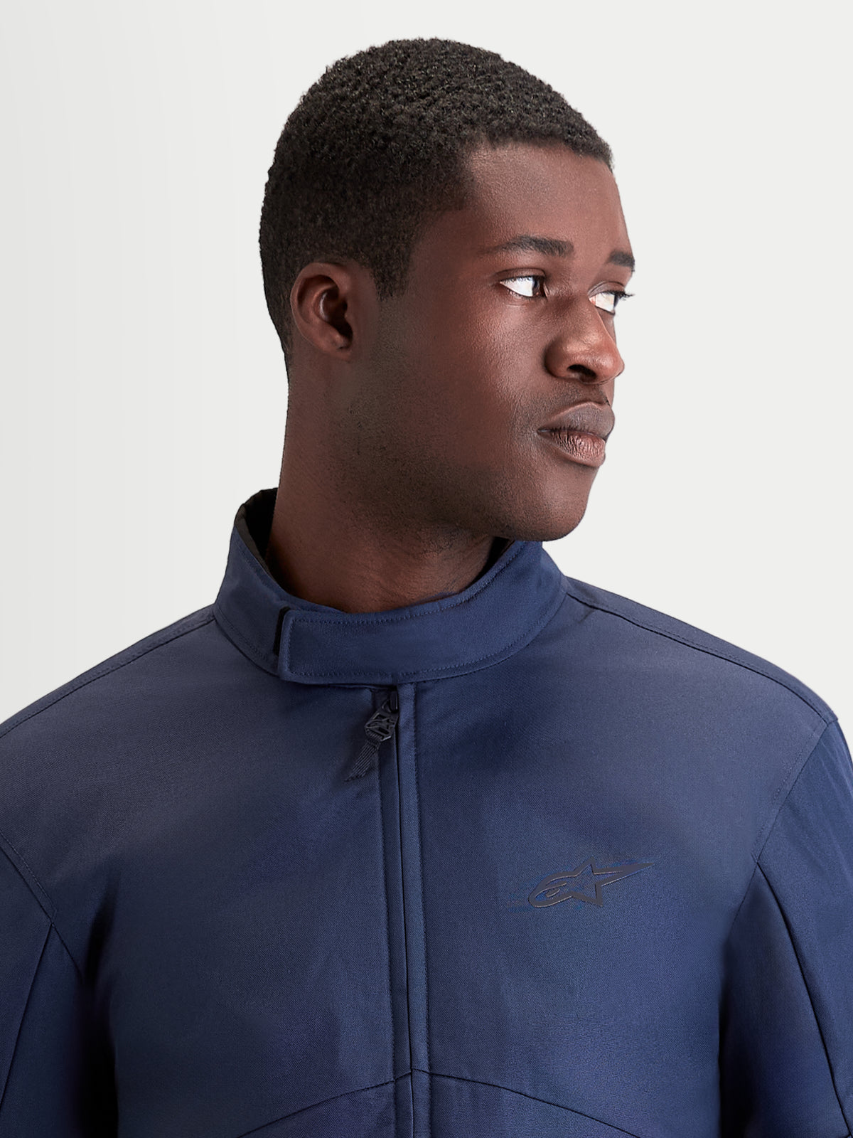 Alpinestars C 1 Waterproof Jacke, urbane Herren-Motorradjacke in Dunkelblau, Nahaufnahme des ergonomischen Kragens und der wasserdichten Konstruktion an einem Model