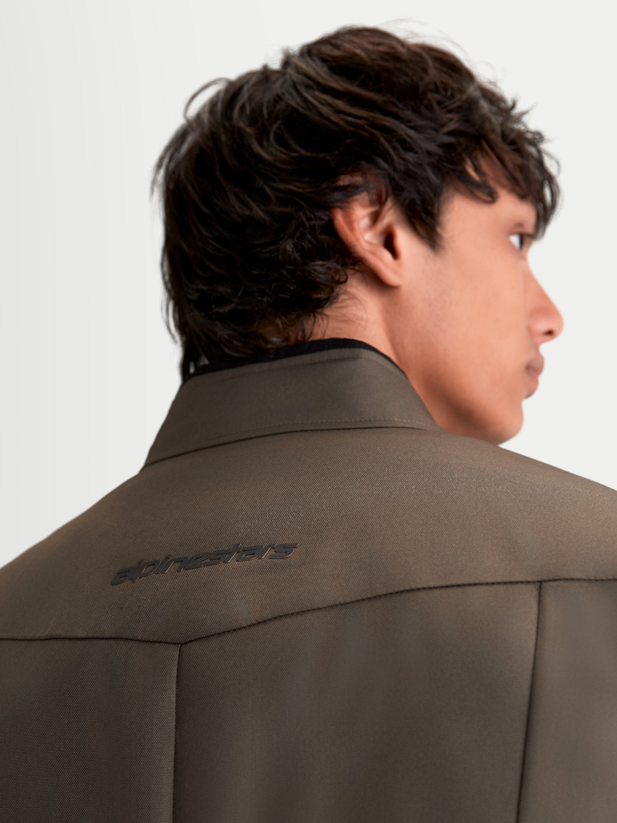 Alpinestars C-1 Waterproof Jacke, urbane zeitgenössische Herren-Motorradjacke aus Textil in Walnussbraun und Schwarz, Detailansicht von hinten mit 3D-Rückenmuster und weichem Kragen am Model