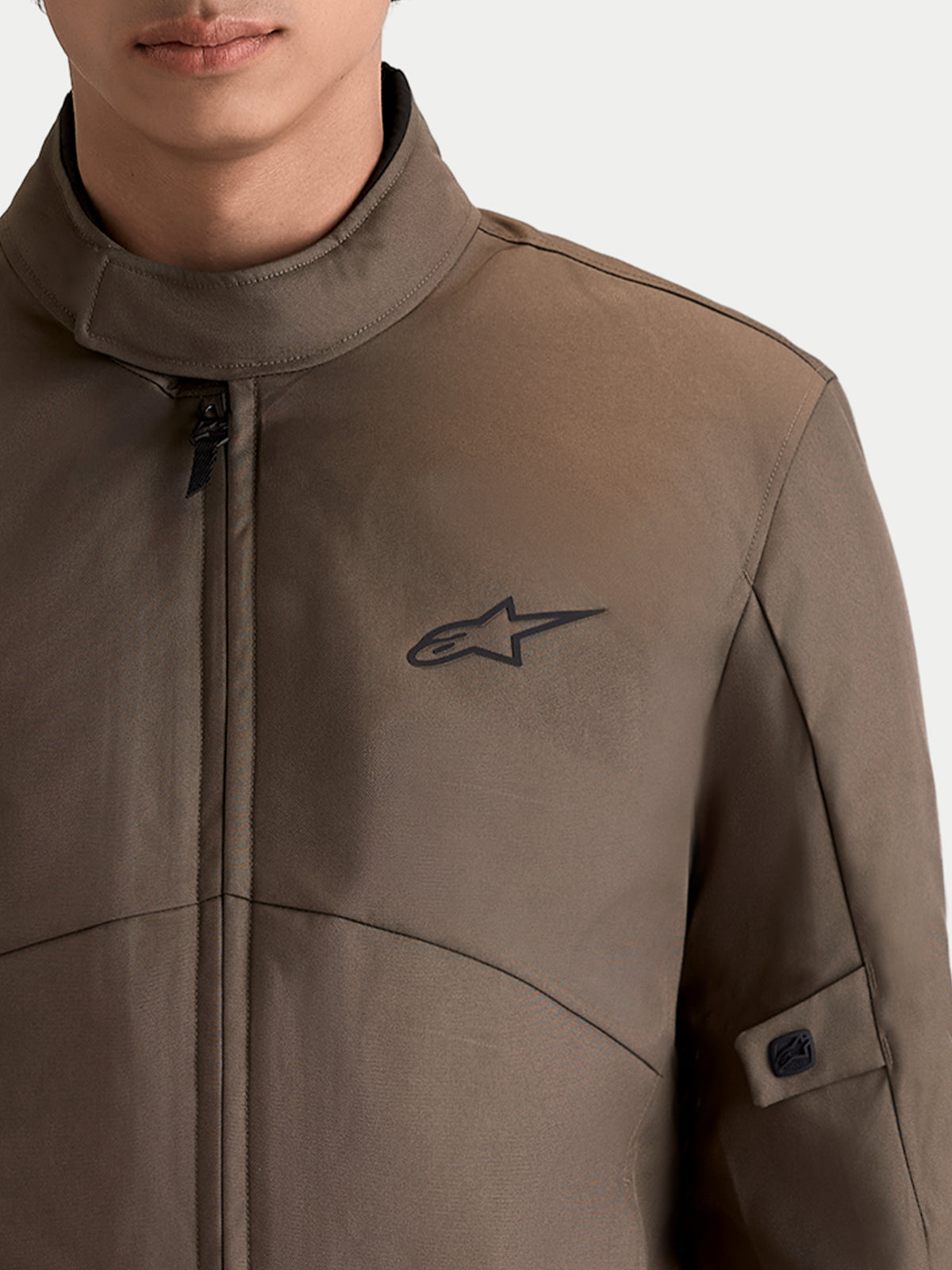 Alpinestars C-1 Waterproof Jacke, urbane Herren-Motorradjacke in Walnussbraun und Schwarz, Nahaufnahme mit weichem Kragen und Astar-Logo-Branding an der Brust