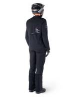Alpinestars AMT-8 Stretch Drystar® XF Jacket, Black, rear view of a rider wearing the jacket with matching black pants and a black helmet, featuring 'Alpinestars Motion Technology' branding on the back, technical stretch material for adventure motorcycle riding