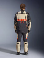 Alpinestars Halo Pro Drystar® XF Laminierte Jacke, Adventure-Motorradjacke, Mastic Black mit orangefarbenem Logo, Rückansicht mit großem Branding am Rücken und modularen Belüftungsreißverschlüssen, getragen mit passender Adventure-Hose für All-Terrain-Performance
