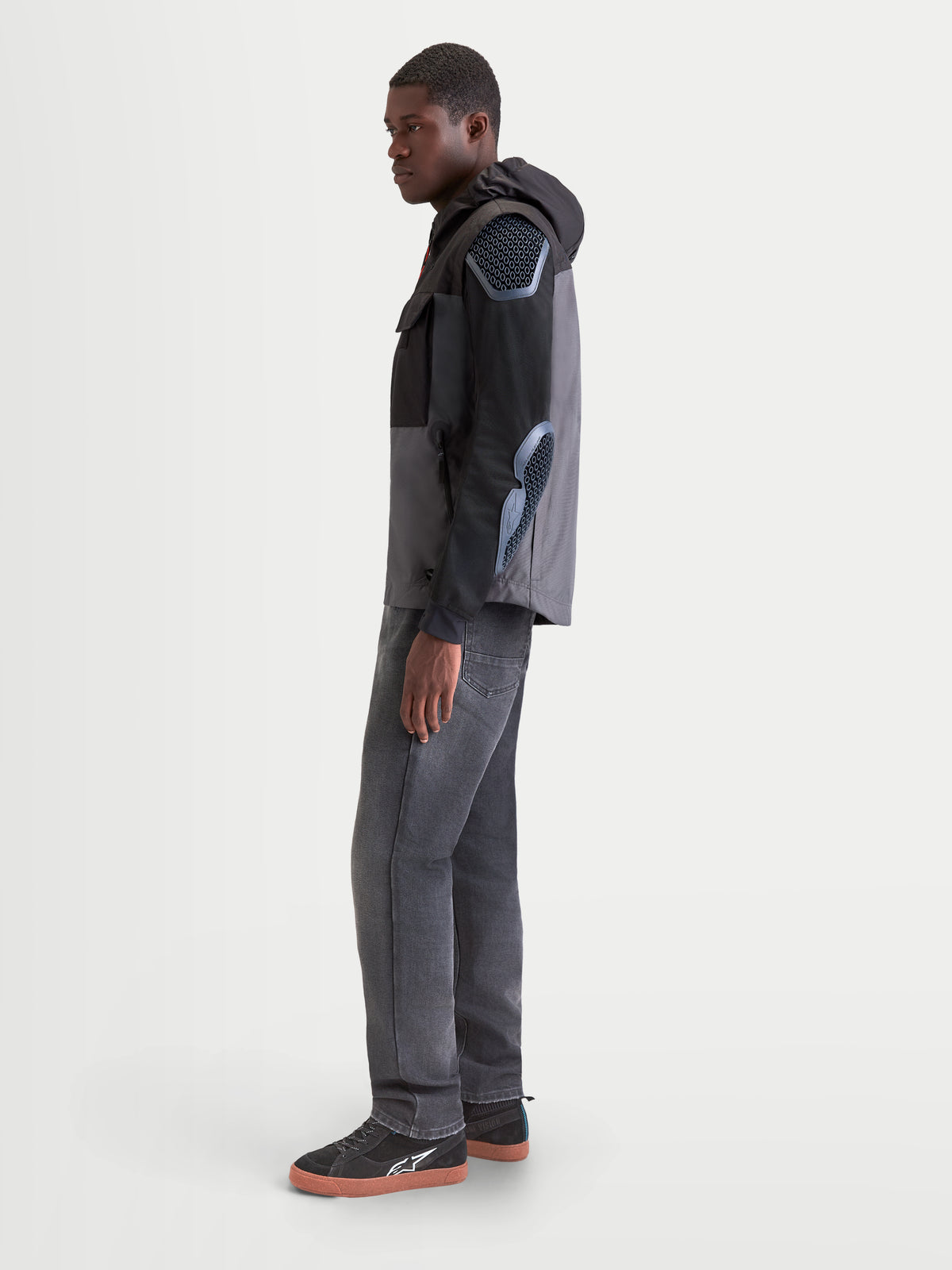 Alpinestars Morfex Parka Wp Jacke, urbane Herren-Motorradjacke in Mondgrau und Schwarz, Seitenansicht an einem Modell im Textil-Parka mit integrierter Kapuze und Protektorendetails