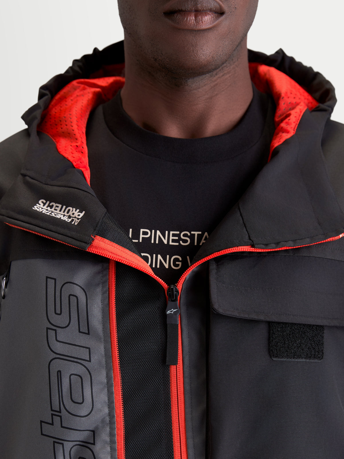 Alpinestars Morfex Parka Wp Jacke, urbane Herren-Motorradjacke in Mondgrau und Schwarz, Detailansicht des integrierten Modells mit Kapuze, rotem Innenfutter und Front-Brusttasche