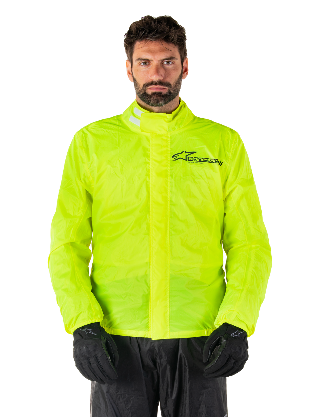 Alpinestars Hurricane Rain V2 Jacke, Motorrad-Regenjacke, Neongelb, getragen von einem Model mit schwarzer Hose und Handschuhen, hoher Kragen mit reflektierenden Laschen, vordere Sturmklappe mit Alpinestars-Logo, hochsichtbare wasserdichte Ausrüstung