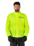 Alpinestars Hurricane Rain V2 Jacke, Motorrad-Regenjacke, Neongelb, getragen von einem Model mit schwarzer Hose und Handschuhen, hoher Kragen mit reflektierenden Laschen, vordere Sturmklappe mit Alpinestars-Logo, hochsichtbare wasserdichte Ausrüstung