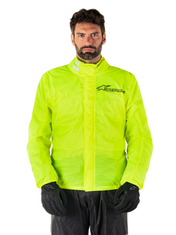 Alpinestars Hurricane Rain V2 Jacket, Motorcycle Rain Jacket, Yellow Fluo, worn by a model with black pants and gloves, high collar with reflective tabs, front storm flap with Alpinestars logo, high-visibility waterproof gear