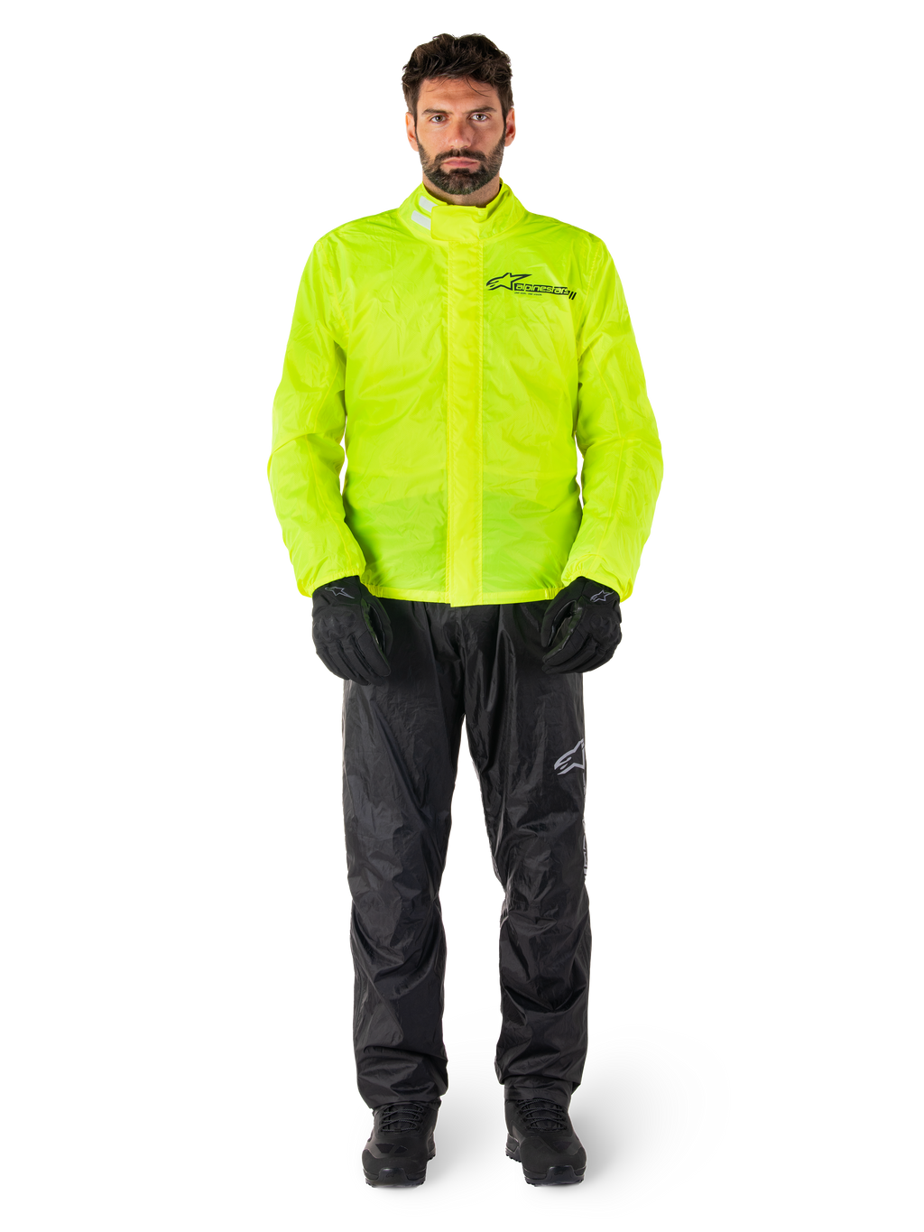 Alpinestars Hurricane Rain V2 Jacke und Hose, Neongelb und Schwarz, wasserdichte Motorrad-Regenkombi, getragen mit schwarzen Handschuhen und Stiefeln, Alpinestars-Logo auf der Brust und am Bein
