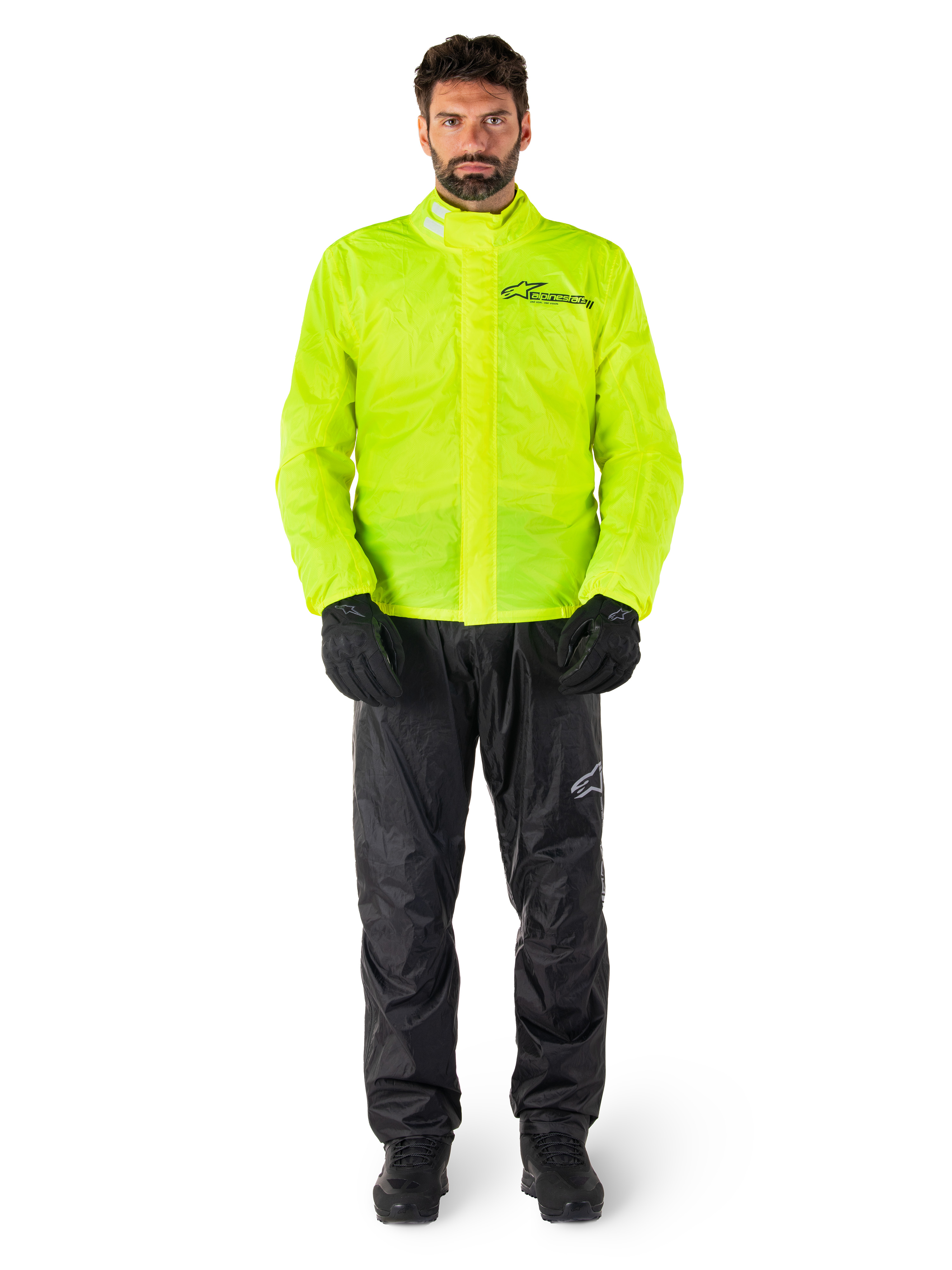 Alpinestars Hurricane Rain V2 Jacke und Hose, Neongelb und Schwarz, wasserdichte Motorrad-Regenkombi, getragen mit schwarzen Handschuhen und Stiefeln, Alpinestars-Logo auf der Brust und am Bein
