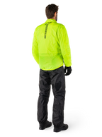 Person von hinten in Alpinestars Hurricane Rain V2 Jacke in Gelb Fluo und Hurricane Rain V2 Hose in Schwarz, vertikales Logo auf dem Jackenrücken, wasserdichte Motorrad-Regenbekleidung mit schwarzen Handschuhen und Stiefeln