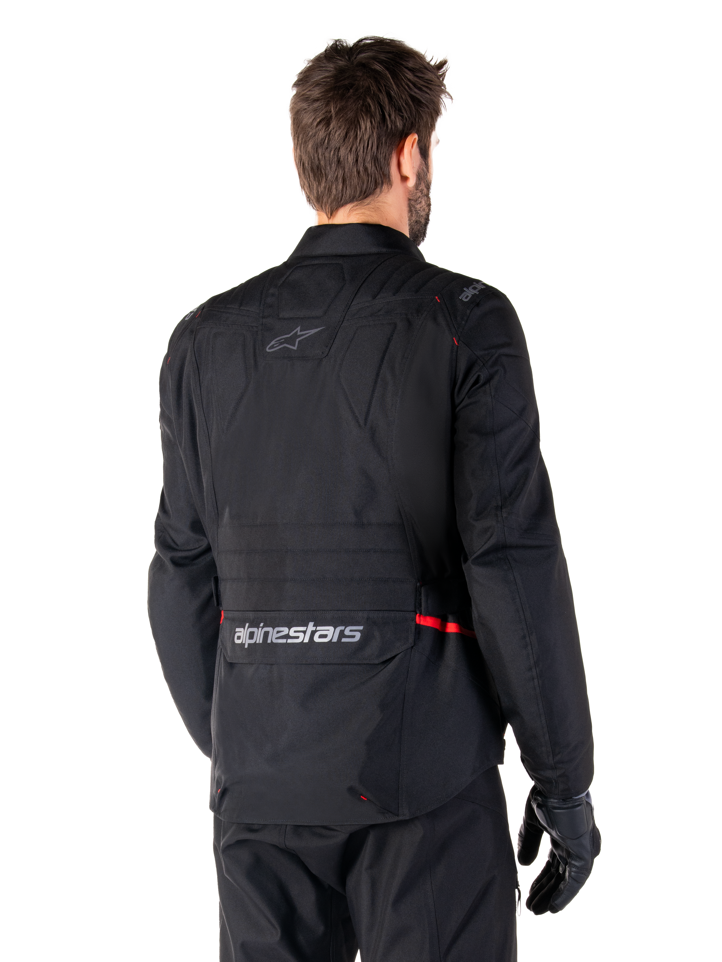 Alpinestars ST-1 Waterproof Jacket, Black, rear view on a model, featuring Alpinestars branding on the lower back cargo pocket, subtle red accents, textile adventure touring motorcycle jacket