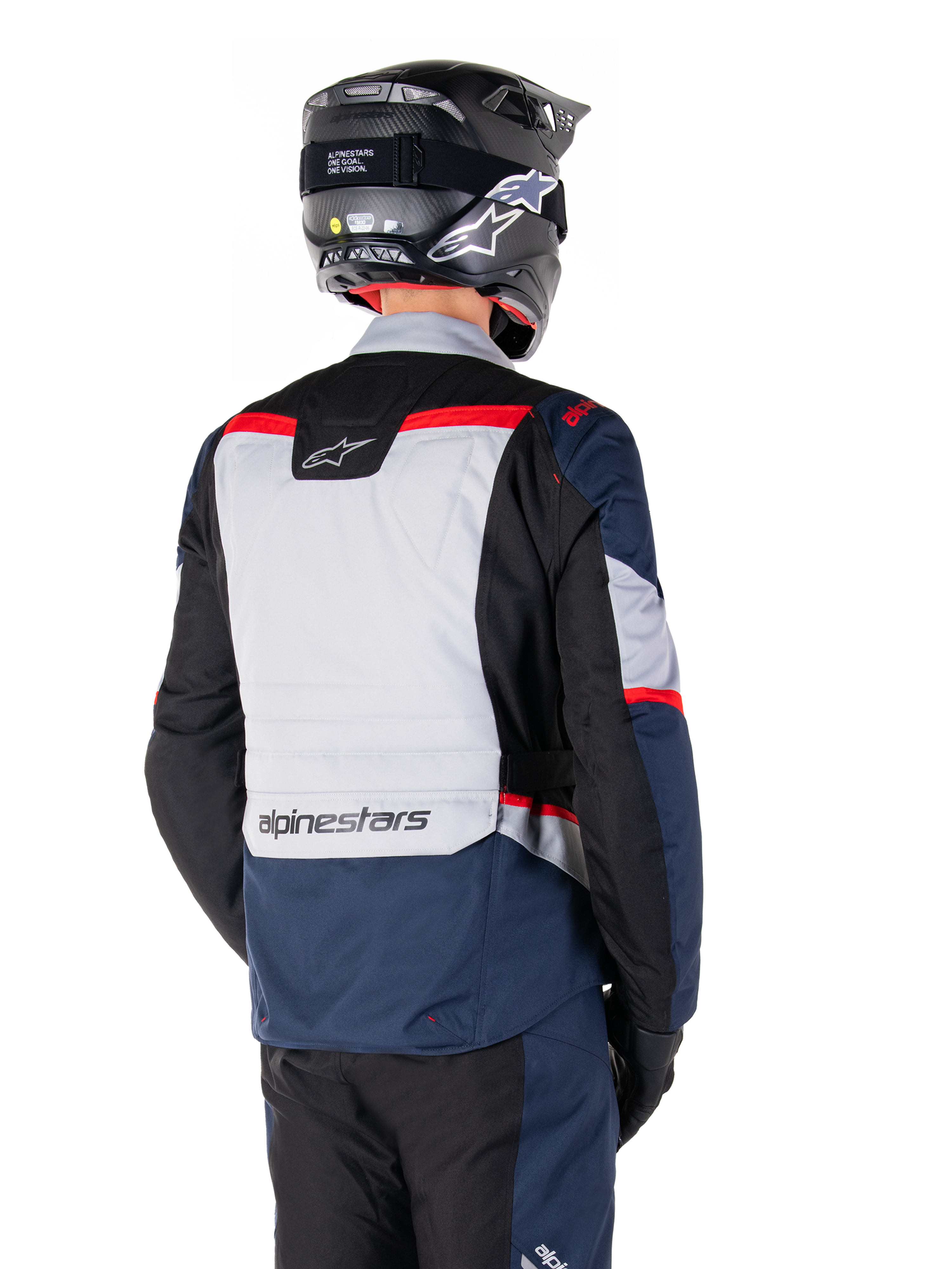 Alpinestars ST-1 Waterproof Jacket, Dark Blue Black and Bright Red, back view on a rider wearing a black adventure helmet, featuring light gray panels and Alpinestars branding, adventure touring motorcycle gear