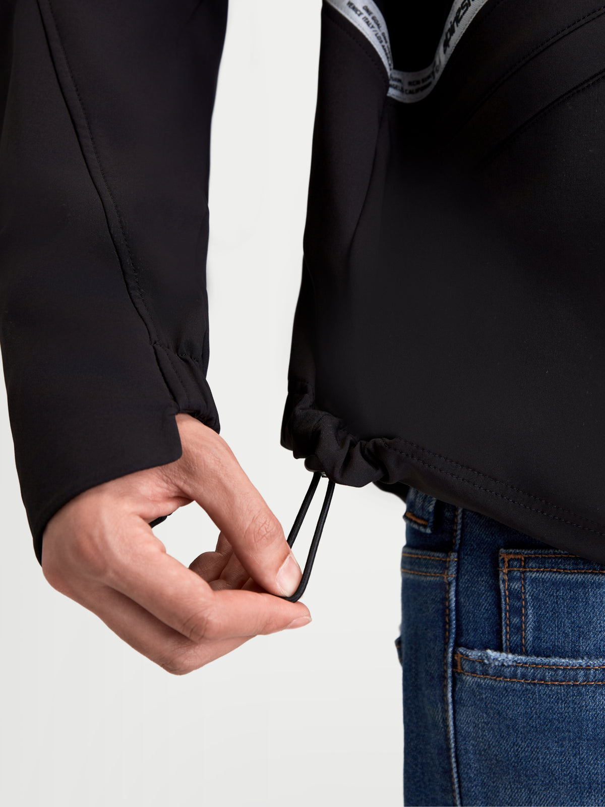 Alpinestars C 5 Drystar Jacke, urbane Herren-Motorradjacke in Schwarz, Nahaufnahme der unteren Saumkordel zur Weitenverstellung und des elastischen Bündchens