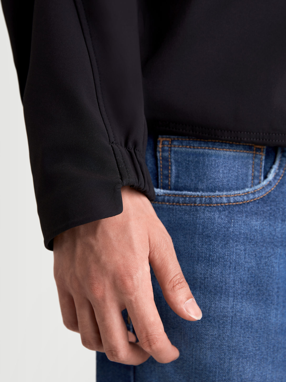 Alpinestars C 5 Drystar Jacke, urbane Herren-Motorradjacke aus Textil, Schwarz, Nahaufnahme der elastischen Bündchendetails an einem Model in blauen Jeans
