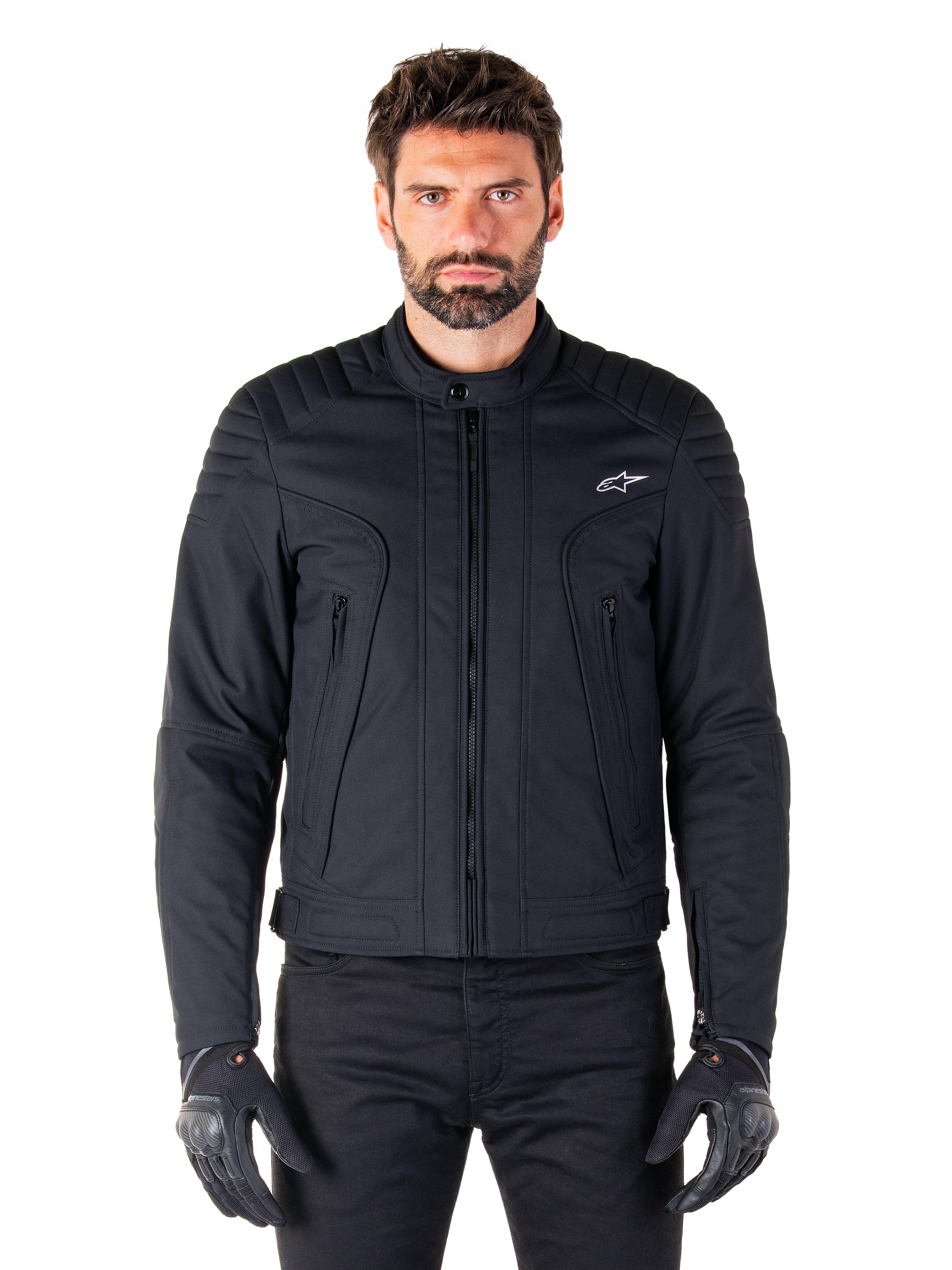 Alpinestars Clayton WR Jacke, schwarze Motorradjacke, von einem Model getragen, mit gesteppten Schulterdetails und technischen Grafiken, zentraler Vislon-Reißverschluss, vertikale Reißverschlusstaschen, kleines weißes Logo auf der Brust, urbane Fahrerausrüstung für den Straßengebrauch