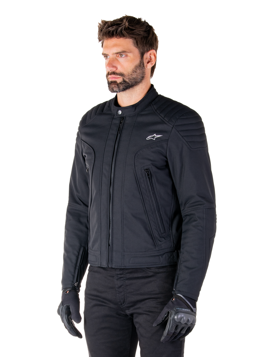 Alpinestars Clayton WR Jacke, Schwarz, urbane Textil-Motorradjacke mit gesteppten Schulter- und Unterarmdetails, schmale Passform, mattes Finish, getragen von einem Fahrer mit schwarzen Handschuhen.