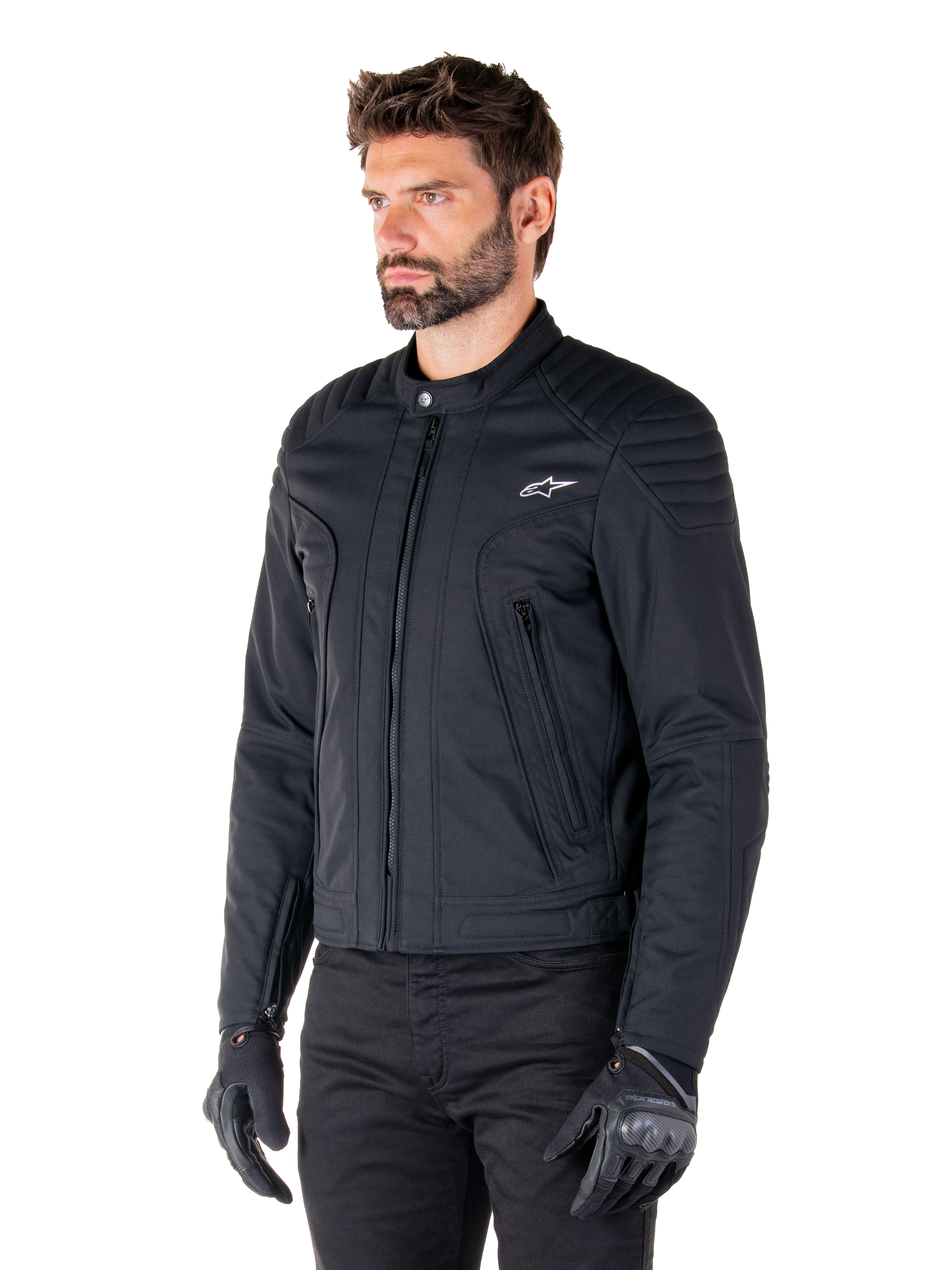 Alpinestars Clayton WR Jacke, Schwarz, urbane Textil-Motorradjacke mit gesteppten Schulter- und Unterarmdetails, schmale Passform, mattes Finish, getragen von einem Fahrer mit schwarzen Handschuhen.