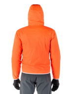 Alpinestars Mohobbs Wasserdichte Jacke, packbarer Regenschutz in Bright Orange Fluo, Rückansicht der leichten Kapuzenjacke, getragen mit dunkelgrauer Motorradhose und schwarzen Handschuhen